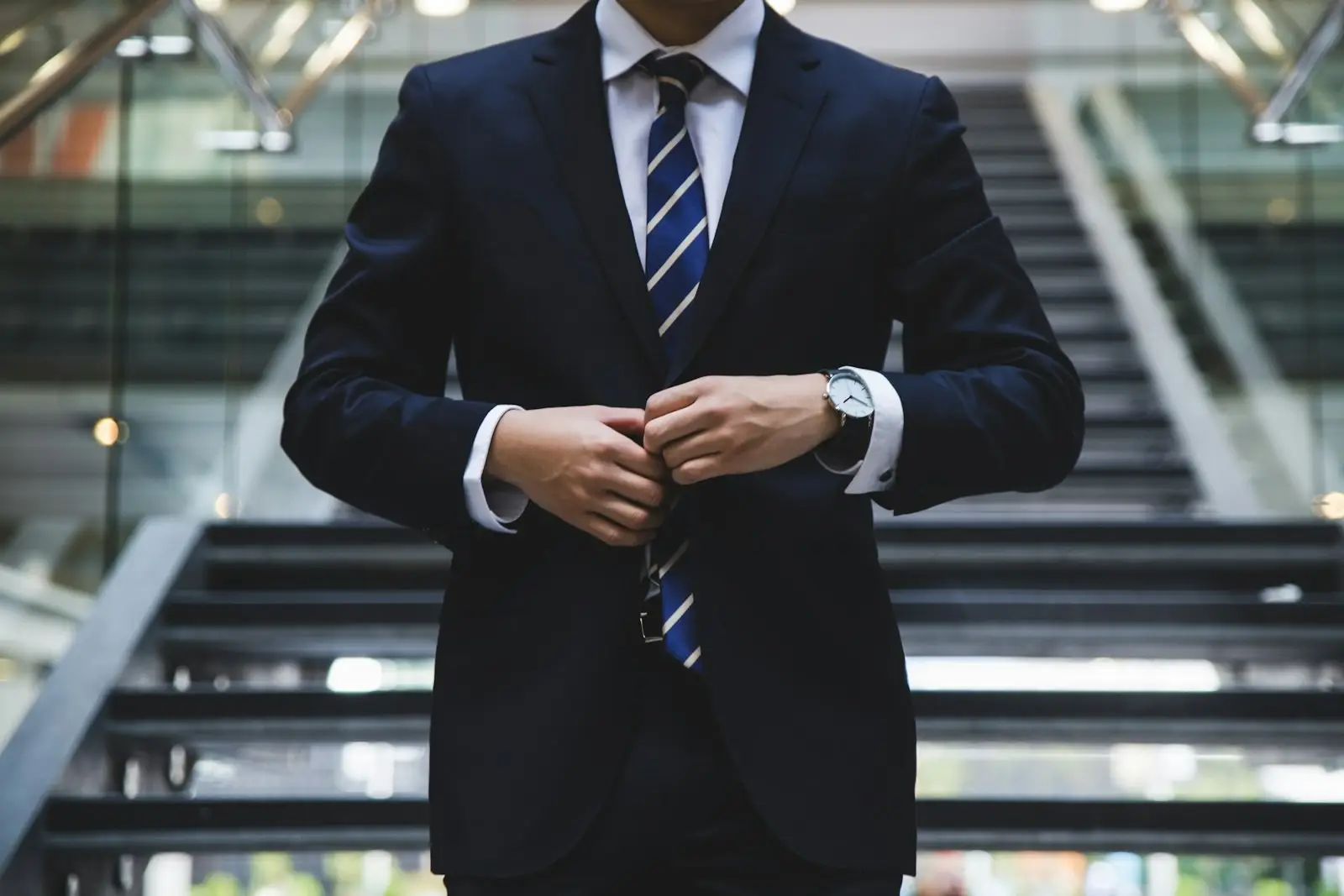 From Strategy to Execution – The Operating Model Gap | Progreziv Business executive in a dark suit buttoning his jacket in a corporate setting, symbolising the transition from strategy to execution
