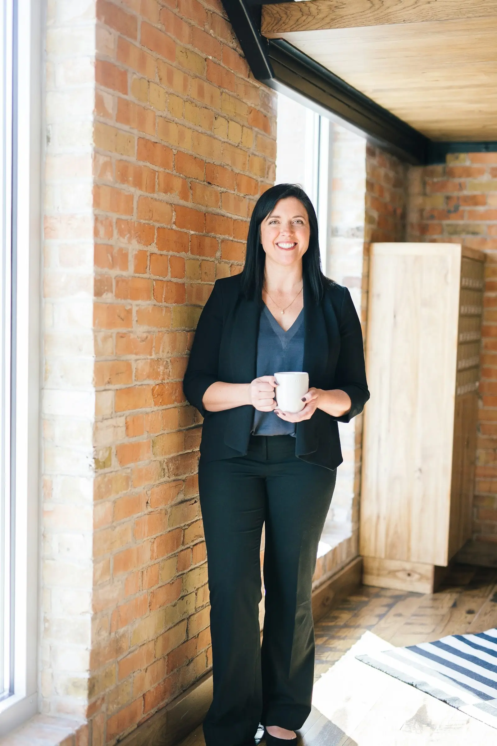 Measuring AI Readiness Without the Hype – Progreziv | Progreziv Confident business professional in a modern brick-walled office, representing pragmatic and grounded measurement of AI readiness