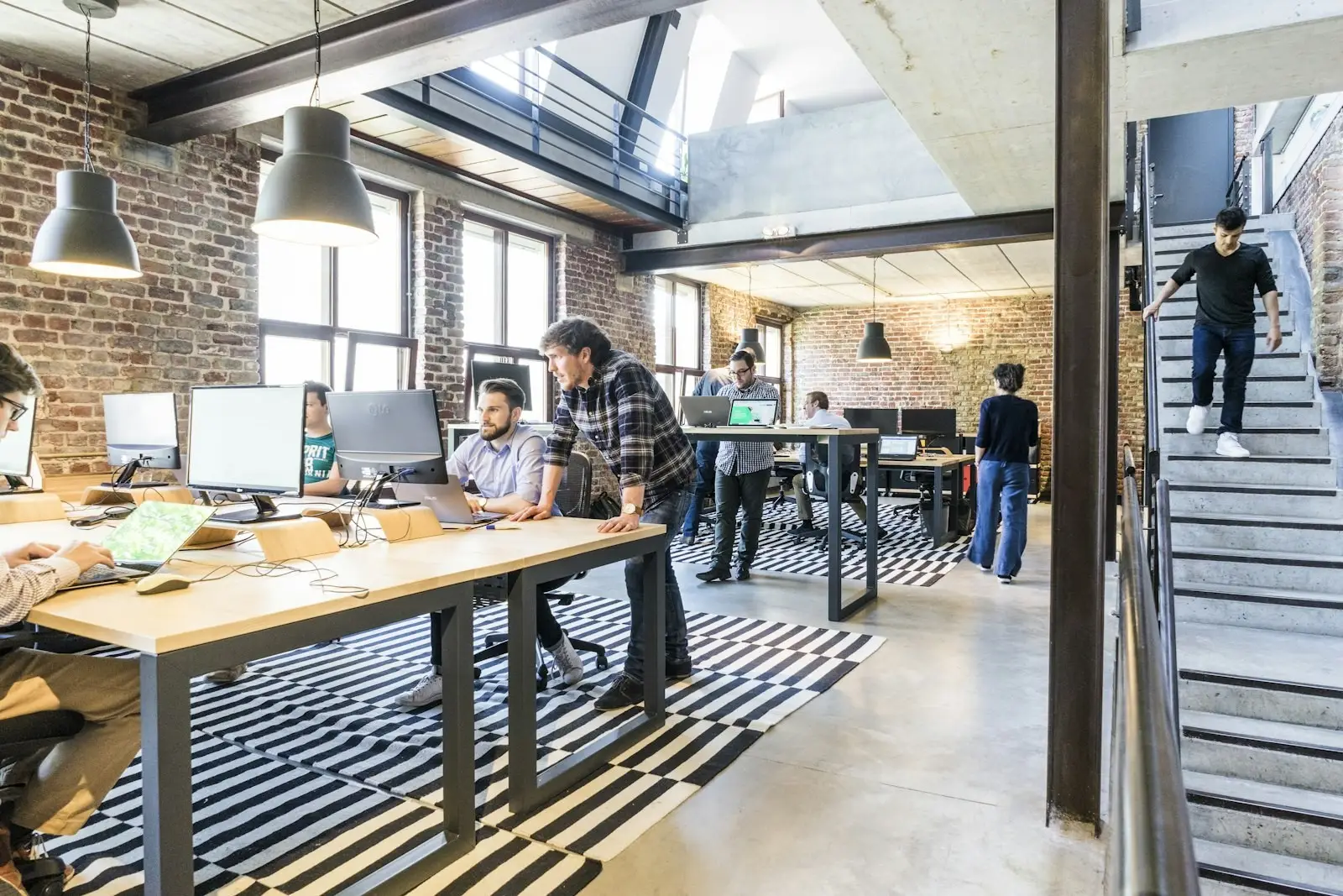 Why We Analyse Work, Not People – Progreziv | Progreziv Open-plan collaborative office with teams working together at shared desks, illustrating the focus on analysing work patterns rather than individual people